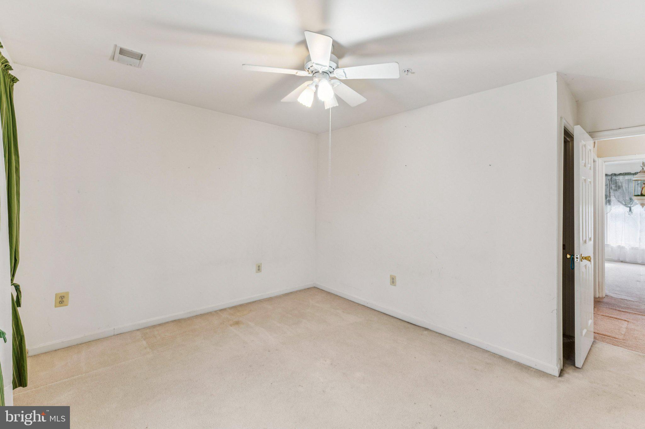 12205 Quick Fox Lane Bowie, MD 20720 - Photo 31 of 39 an empty room with a ceiling fan and a window