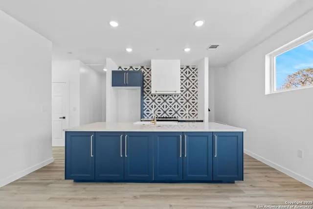 a room with a bed cabinets and a window