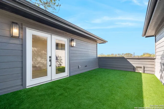 a view of a patio with couches chairs and a floor to ceiling window and potted plants