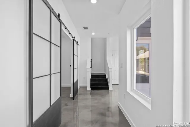 an empty room with windows and ceiling fan