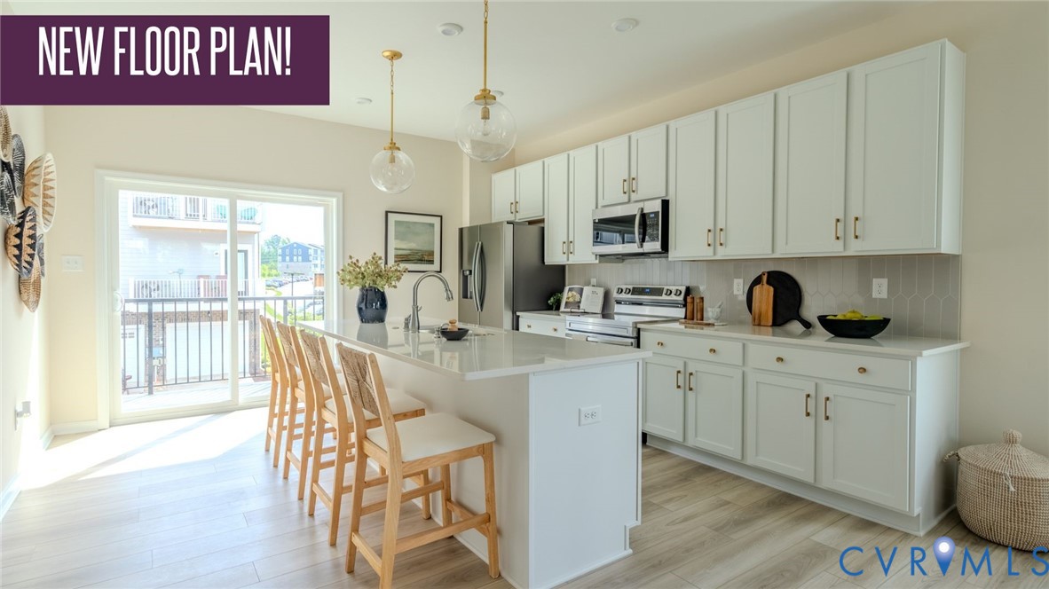 a kitchen with stainless steel appliances granite countertop a stove a sink dishwasher and a refrigerator with wooden floor