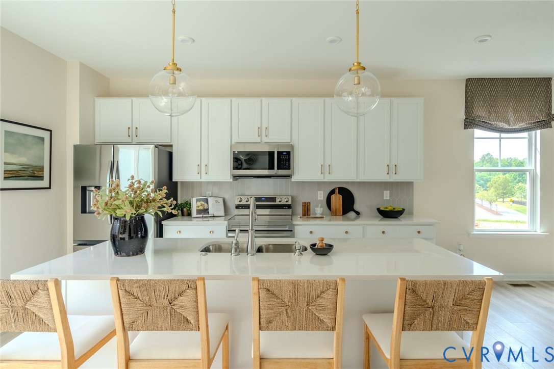 0 Flying Cloud Alley, Unit 9 Midlothian, VA 23113 - Photo 5 of 22 a kitchen with stainless steel appliances granite countertop a stove top oven a sink dishwasher and white cabinets with wooden floor