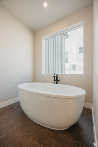 5910 Canyon Rim Road, Unit 619 Lehi, UT 84048 - Photo 35 of 52 Freestanding oval soaking tub with a matte black floor-mounted faucet, set against a large window