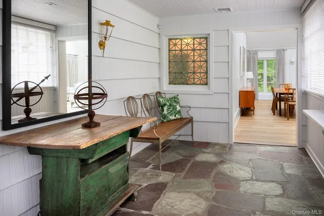 a view of living room kitchen with stainless steel appliances granite countertop a sink a table and chairs in it