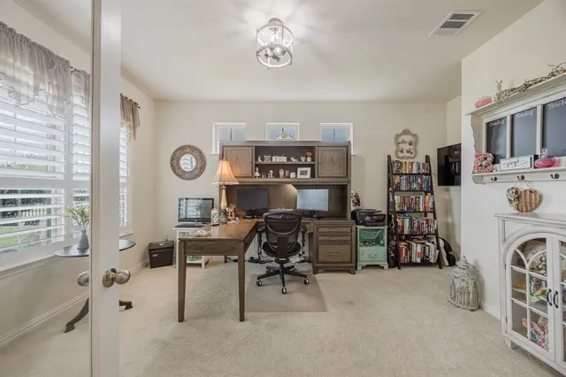 a view of a workspace with furniture and a window