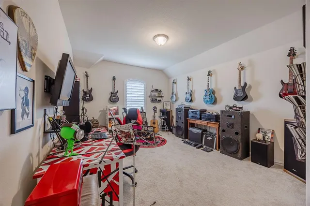 a bedroom with a bed and a lamp on dresser