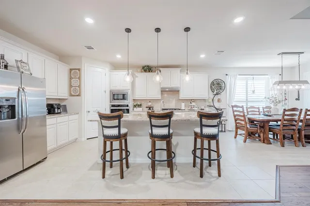 a large kitchen with a table and chairs