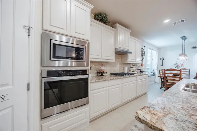 a kitchen with stainless steel appliances granite countertop a stove microwave and cabinets