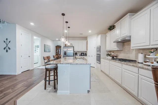 a kitchen with stainless steel appliances kitchen island granite countertop a sink and cabinets