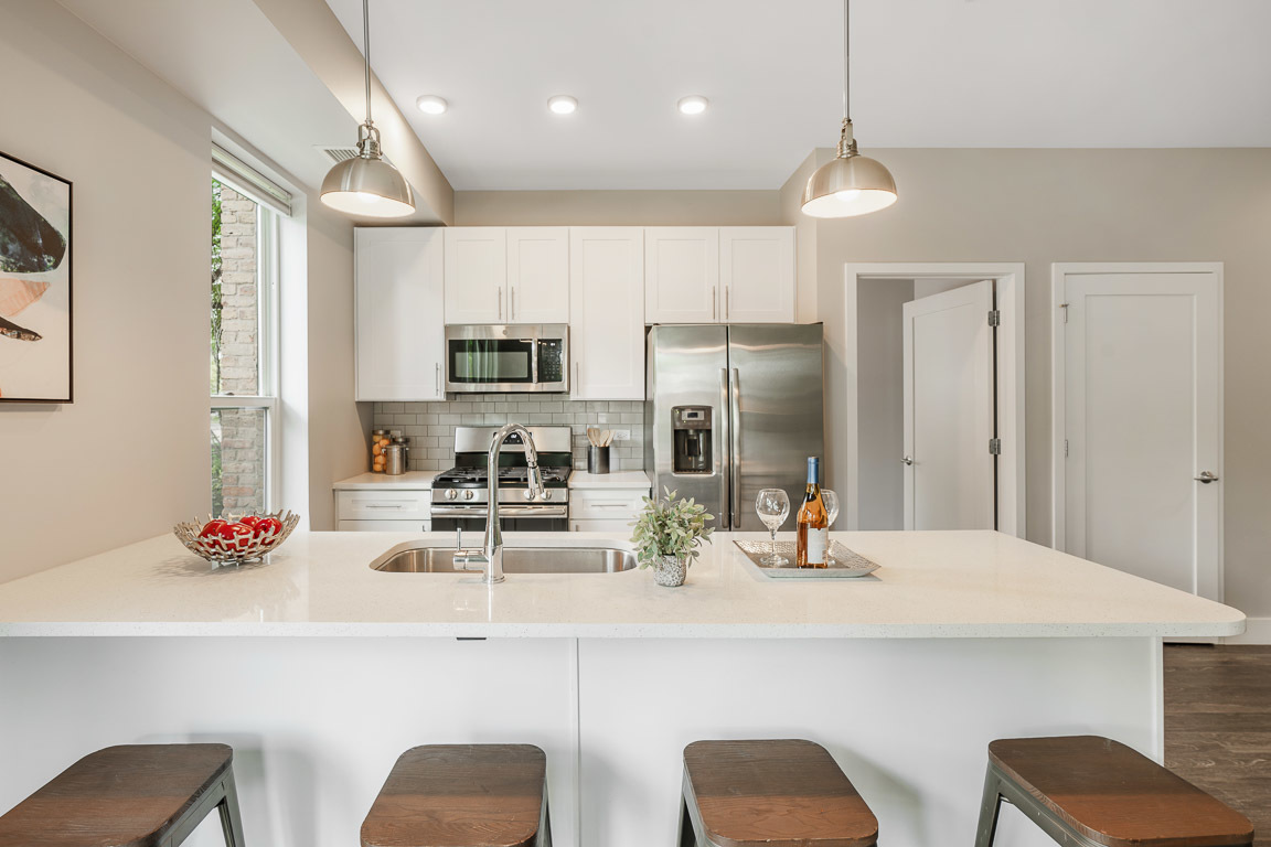 101 West Liberty Street, Unit 221 Barrington, IL 60010 - Photo 2 of 17 a kitchen with stainless steel appliances kitchen island granite countertop a dining table chairs refrigerator and sink