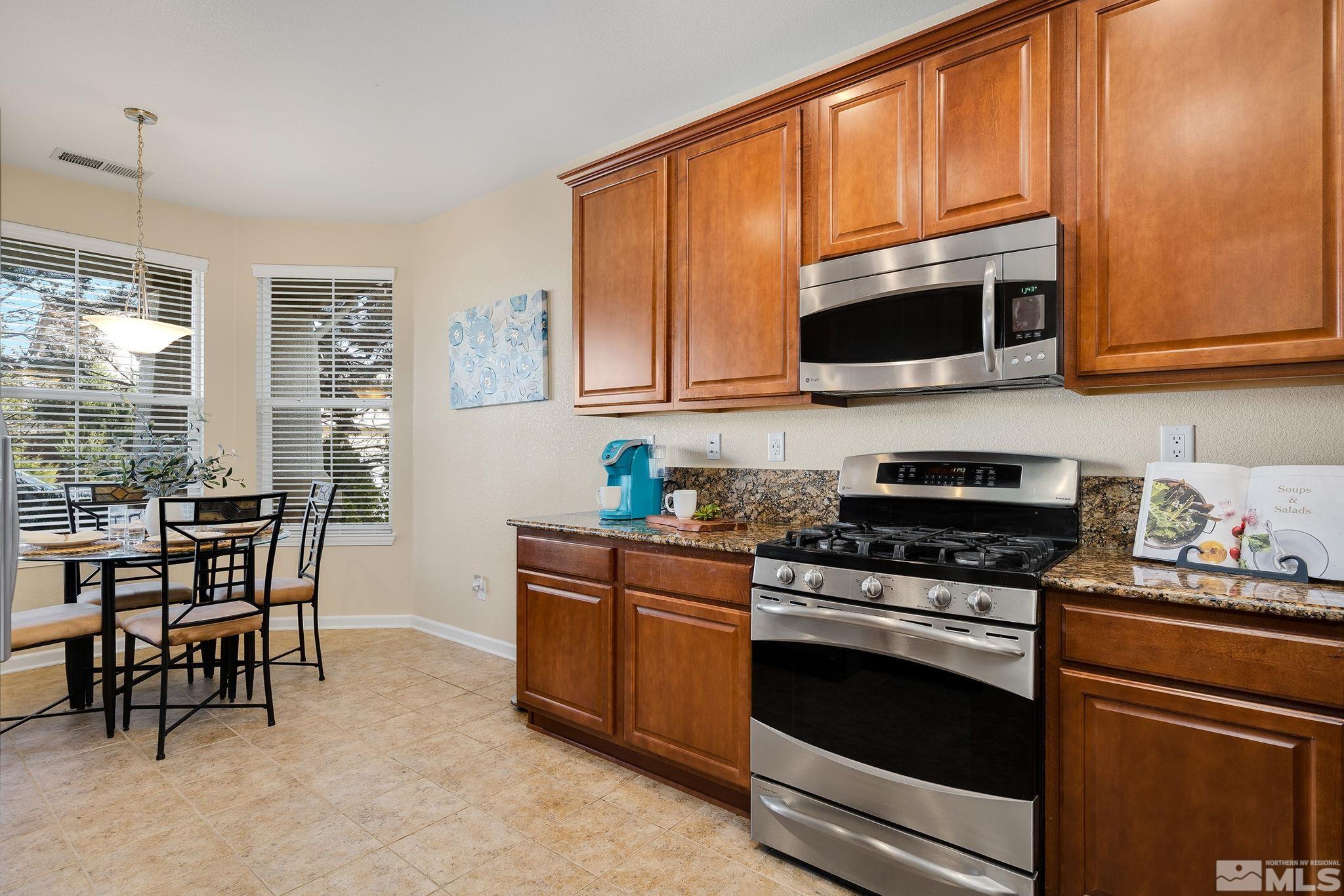 510 Roseben Drive Reno, NV 89521 - Photo 8 of 20 a kitchen with stainless steel appliances granite countertop wooden cabinets a stove top oven a sink and dishwasher a refrigerator with wooden floor