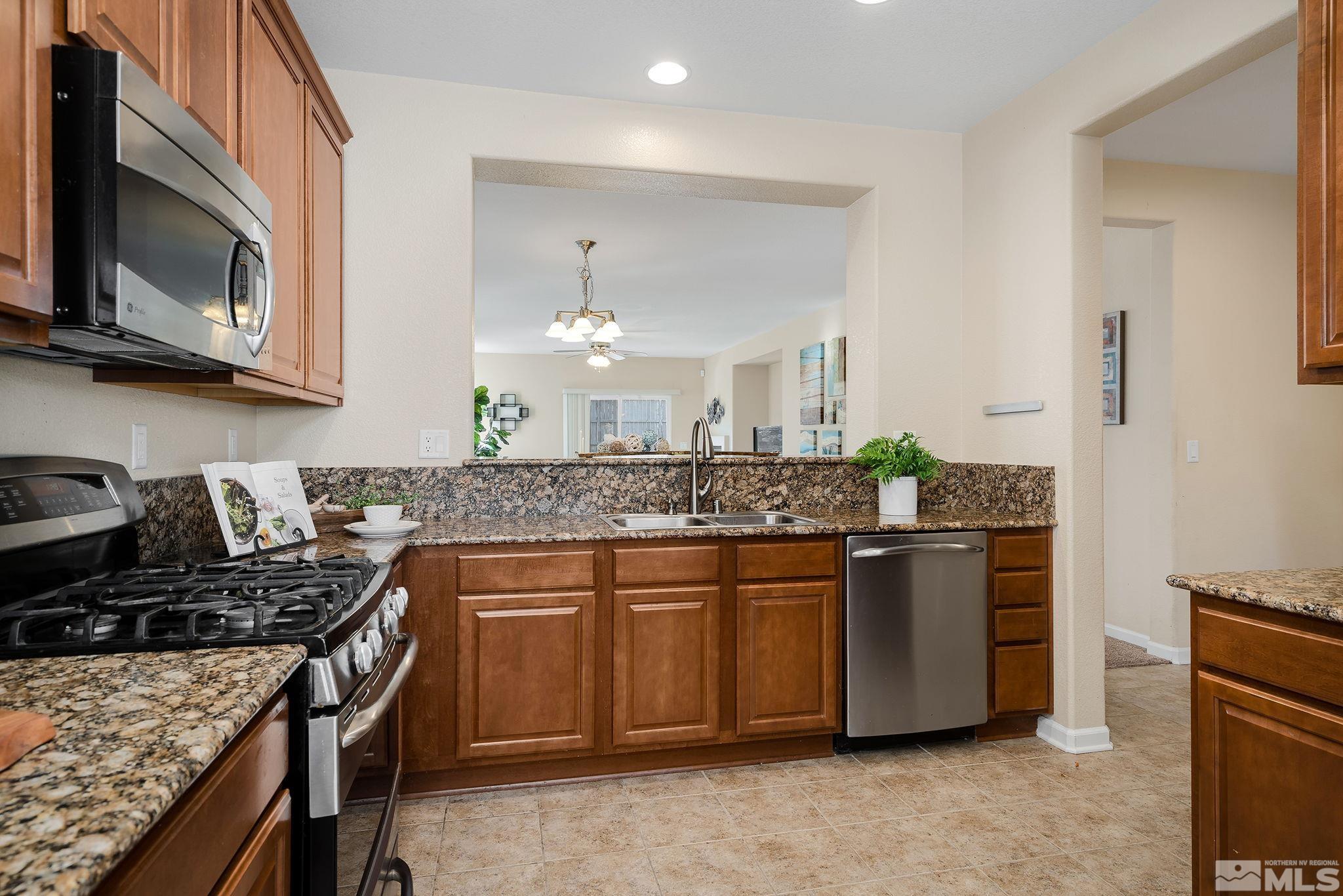 510 Roseben Drive Reno, NV 89521 - Photo 10 of 20 a kitchen with stainless steel appliances granite countertop a stove and a microwave