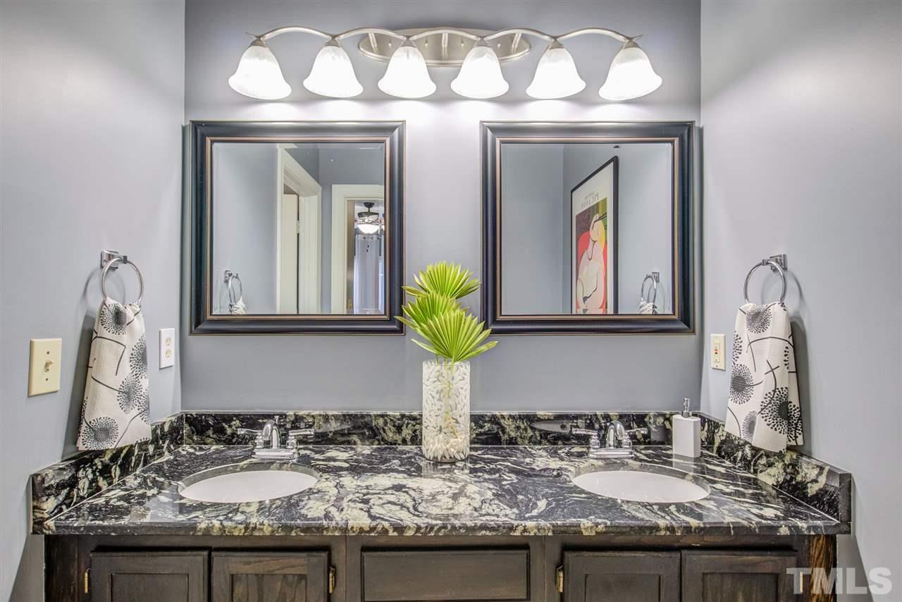 6908 Spring Drive Raleigh, NC 27613 - Photo 17 of 30 a bathroom with a sink and two mirror