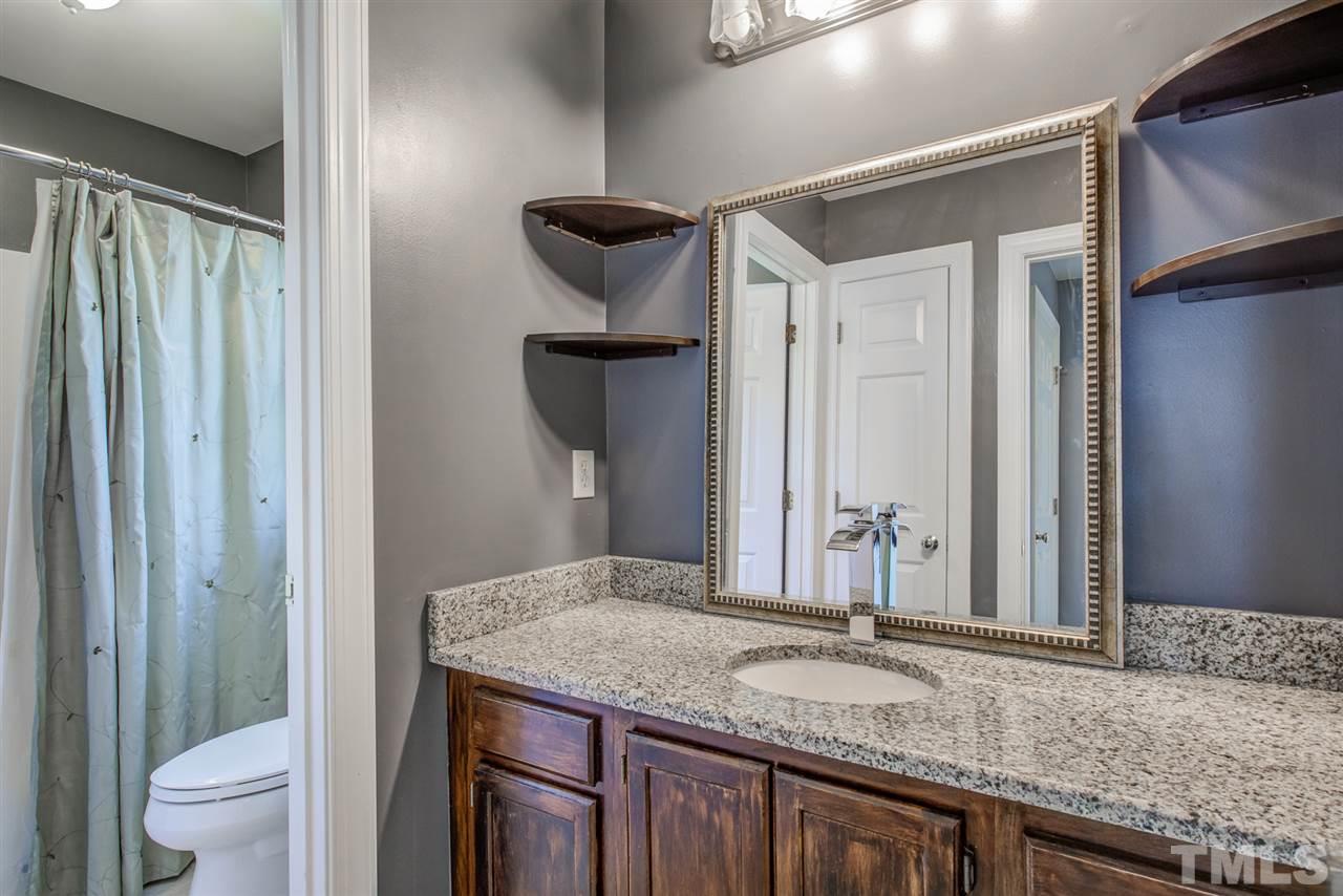 6908 Spring Drive Raleigh, NC 27613 - Photo 23 of 30 a bathroom with a granite countertop sink and a mirror