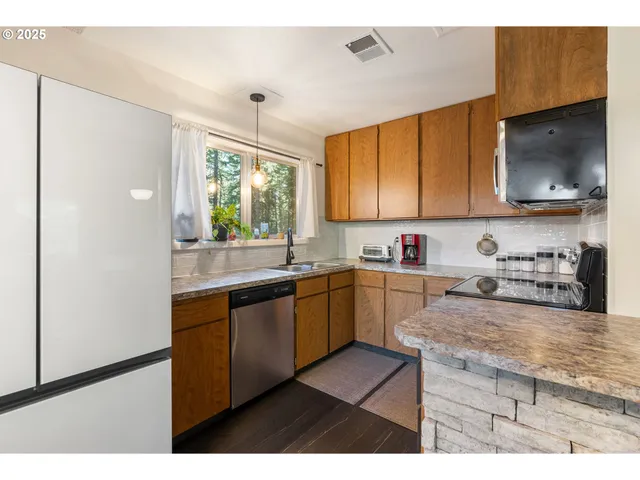 a kitchen with stainless steel appliances granite countertop a stove a sink and a microwave