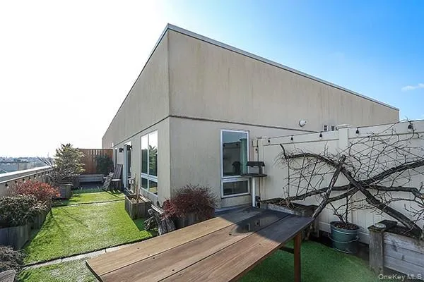 a backyard of a house with plants and garage