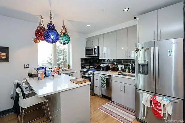 a kitchen with stainless steel appliances granite countertop a sink dishwasher a refrigerator with a dining table and chairs