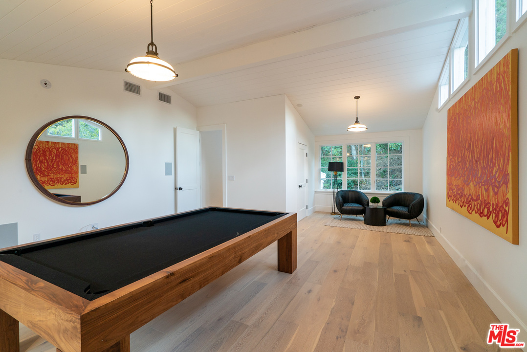 2794 Mandeville Canyon Road Los Angeles, CA 90049 - Photo 17 of 18 a living room with a bed a couch and a large window