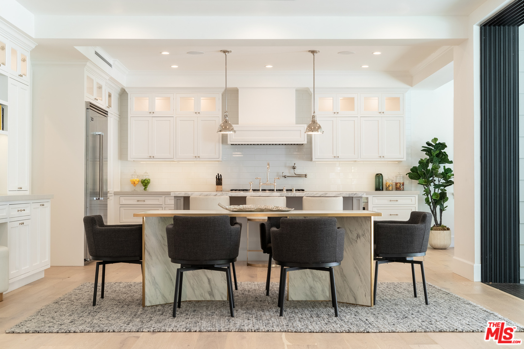 2794 Mandeville Canyon Road Los Angeles, CA 90049 - Photo 7 of 18 a kitchen with a table chairs sink and cabinets