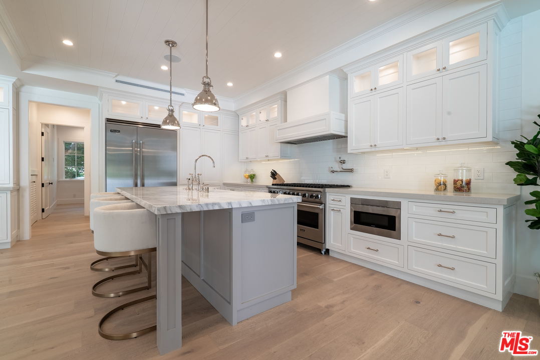 2794 Mandeville Canyon Road Los Angeles, CA 90049 - Photo 8 of 18 a kitchen with a white stove cabinets and wooden floor
