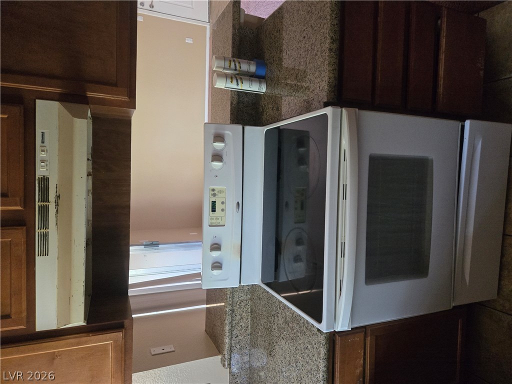 7200 West Pirates Cove Road, Unit 2047 Las Vegas, NV 89145 - Photo 5 of 17 The kitchen features an electric range and matching oven, complemented by a range hood.