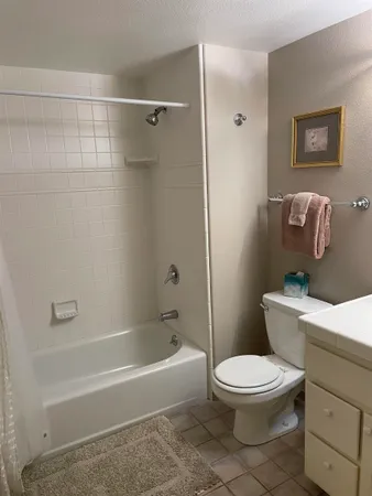 a bathroom with a granite countertop toilet sink and mirror