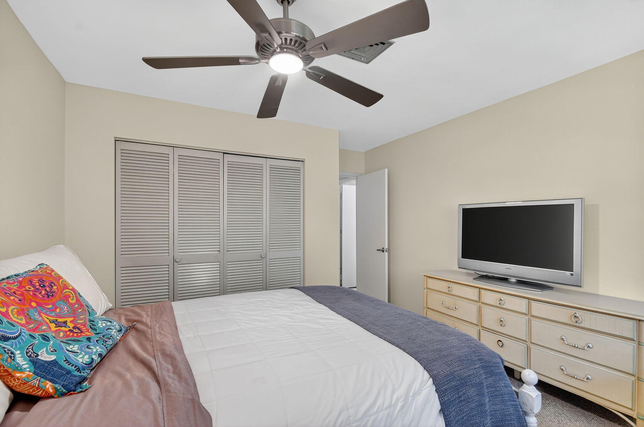 324 Orange Tree Drive, Unit 5 Atlantis, FL 33462 - Photo 15 of 29 a bedroom with a bed and a flat screen tv