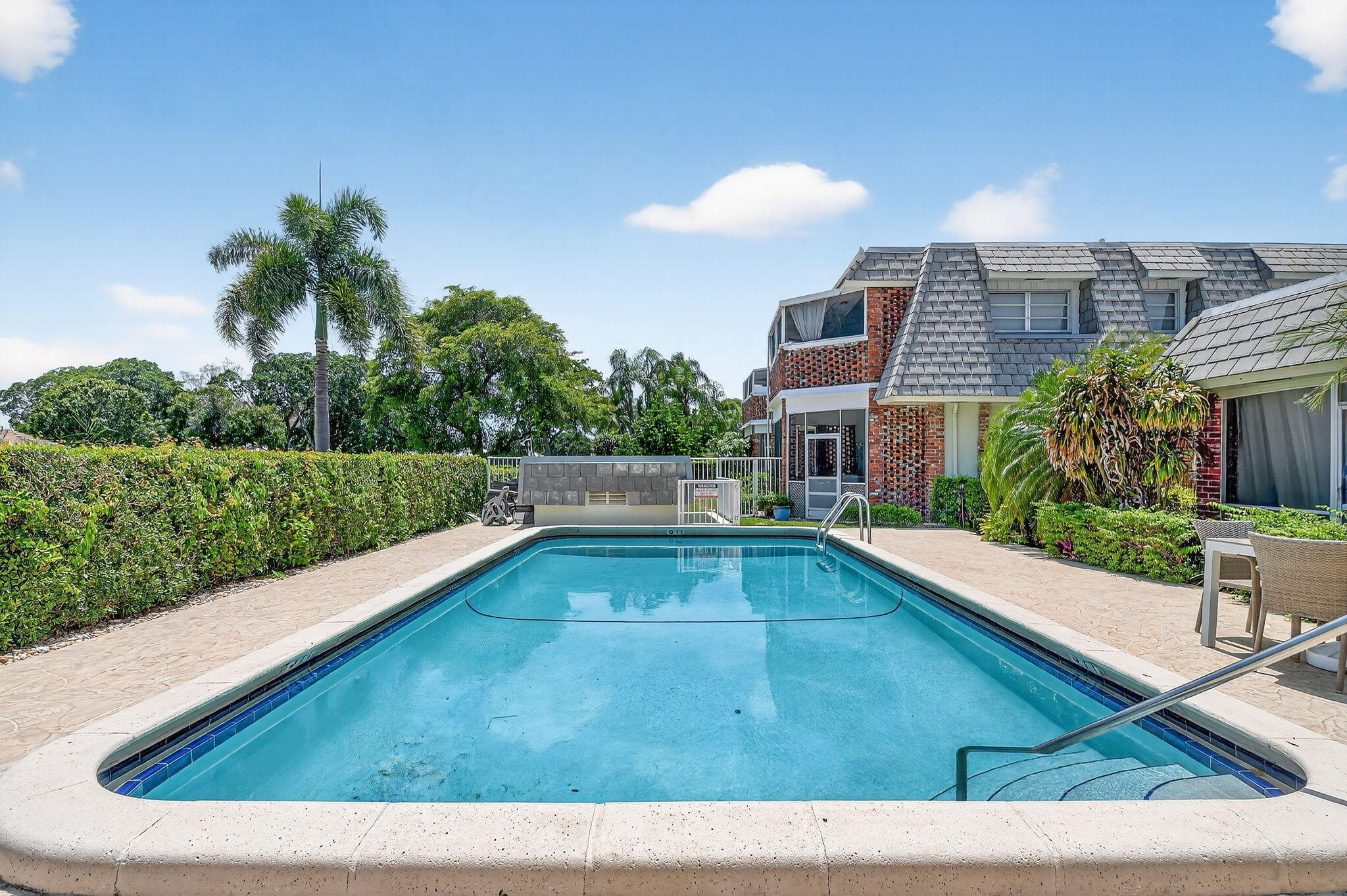 324 Orange Tree Drive, Unit 5 Atlantis, FL 33462 - Photo 24 of 29 a view of swimming pool with chairs