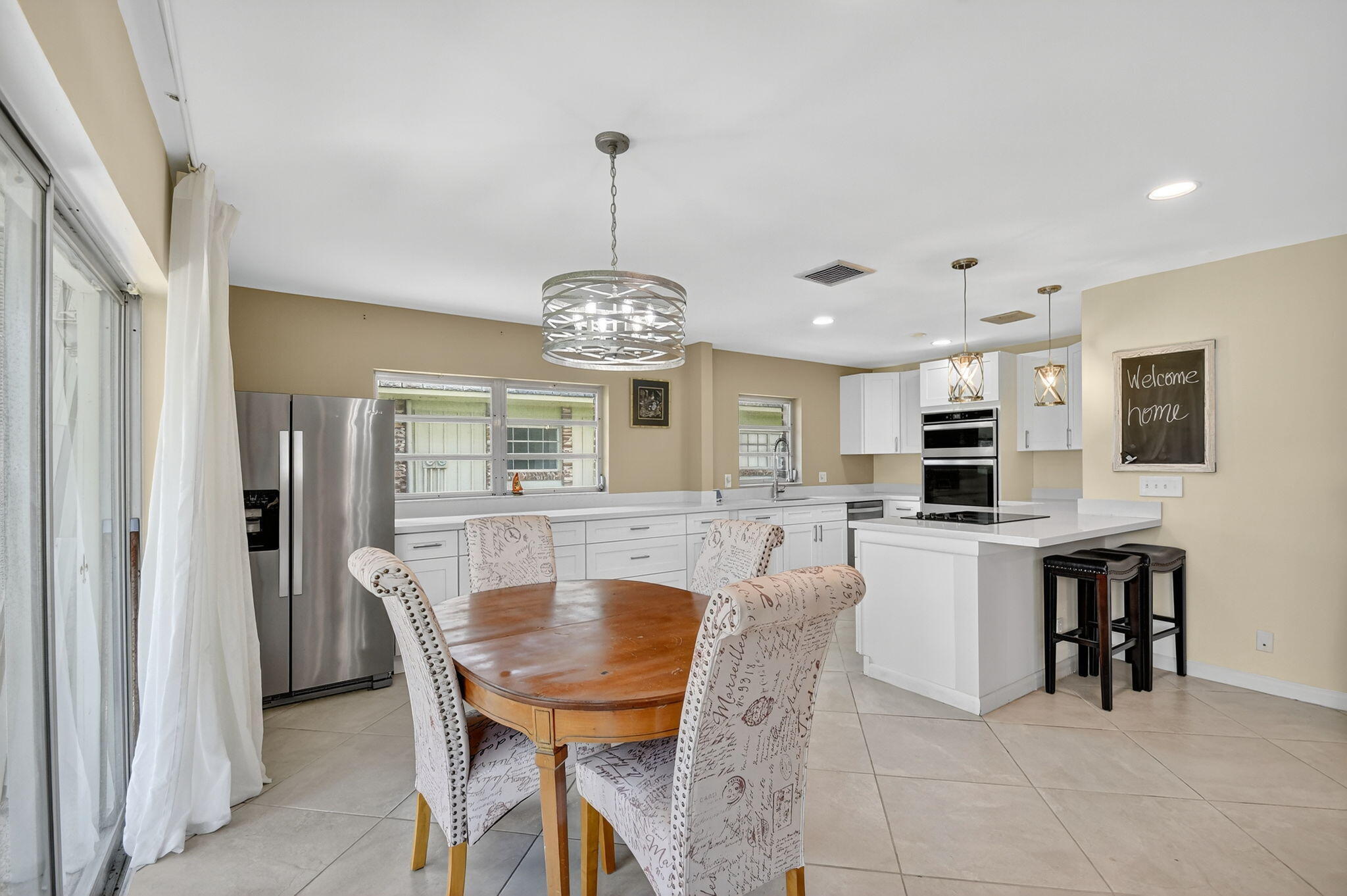 324 Orange Tree Drive, Unit 5 Atlantis, FL 33462 - Photo 5 of 29 a view of a dining room with furniture and chandelier
