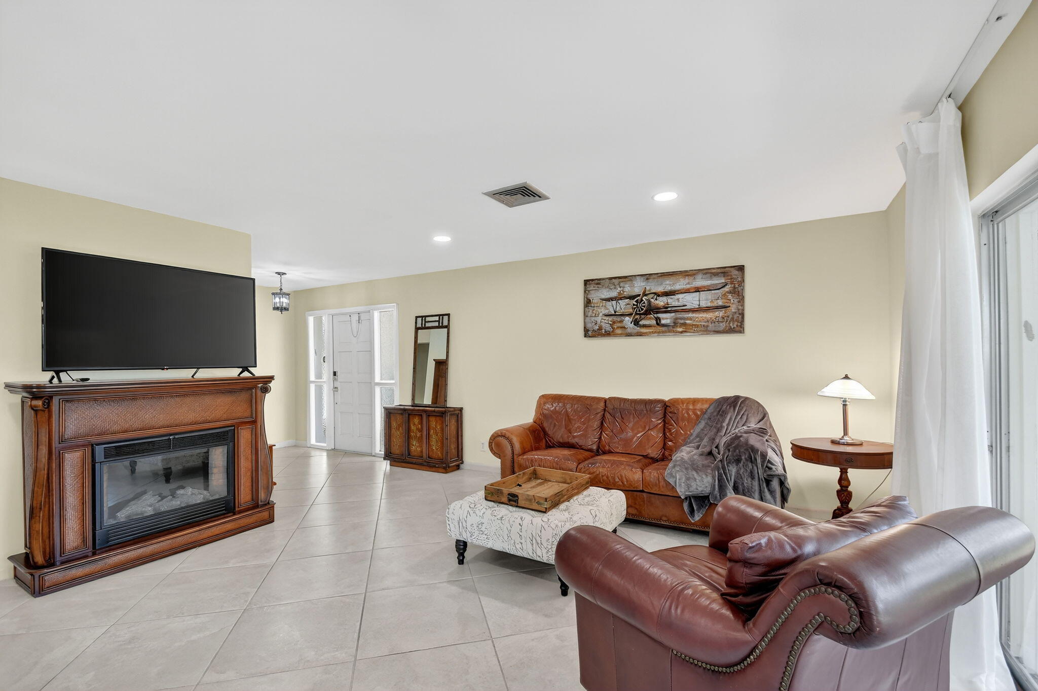 324 Orange Tree Drive, Unit 5 Atlantis, FL 33462 - Photo 8 of 29 a living room with furniture a flat screen tv and a fireplace