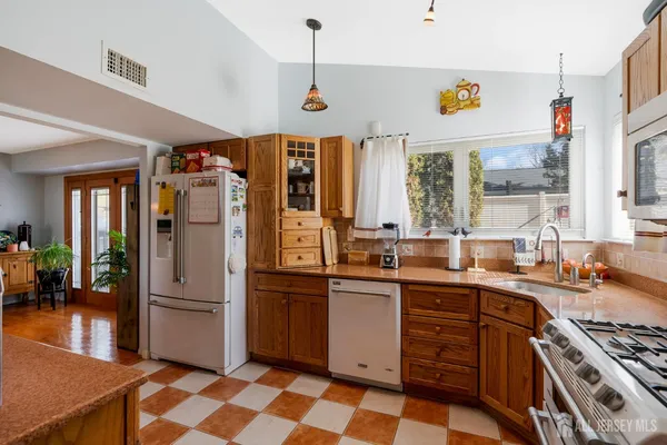 a kitchen with stainless steel appliances a sink a stove a refrigerator and cabinets