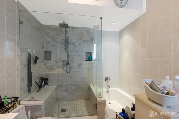 a bathroom with a granite countertop bathtub shower and toilet