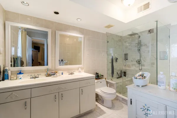a bathroom with a double vanity sink toilet and shower
