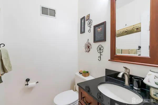 a bathroom with a toilet mirror vanity and a sink