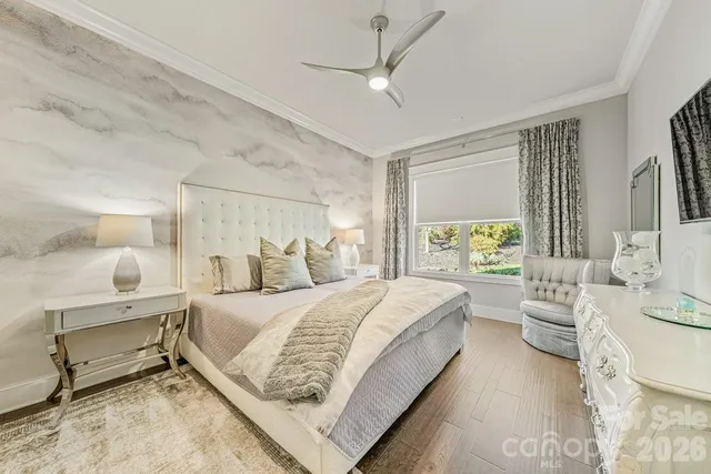 a bedroom with a large bed and a chandelier