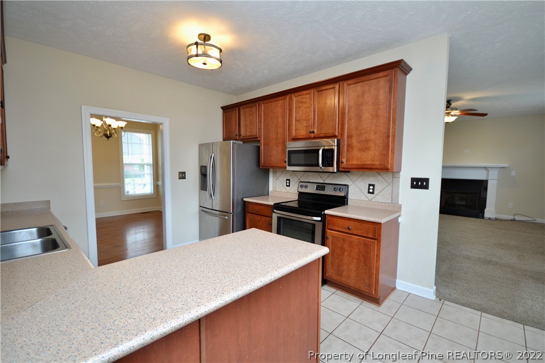3608 Talus Road Fayetteville, NC 28306 - Photo 14 of 46 a kitchen with stainless steel appliances a refrigerator stove top oven a sink and dishwasher