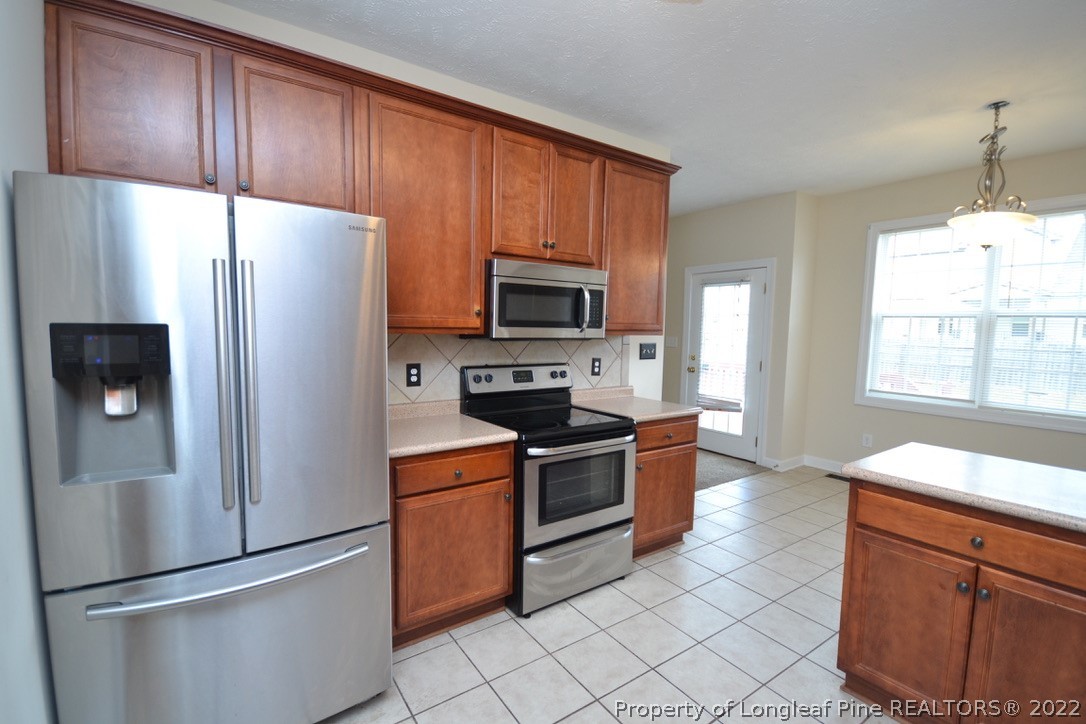 3608 Talus Road Fayetteville, NC 28306 - Photo 16 of 46 a kitchen with granite countertop a refrigerator stove and microwave