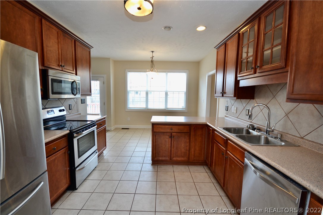 3608 Talus Road Fayetteville, NC 28306 - Photo 18 of 46 a kitchen with stainless steel appliances granite countertop a sink stove and cabinets