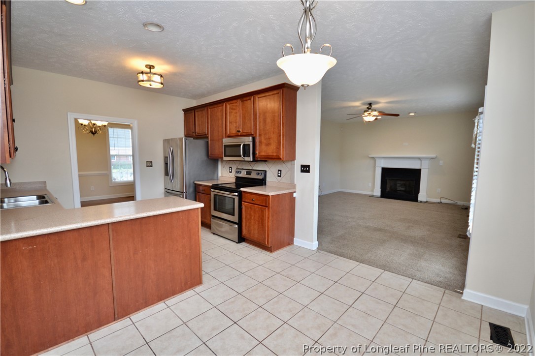 3608 Talus Road Fayetteville, NC 28306 - Photo 19 of 46 a kitchen with kitchen island granite countertop a stove top oven a sink and a counter top space