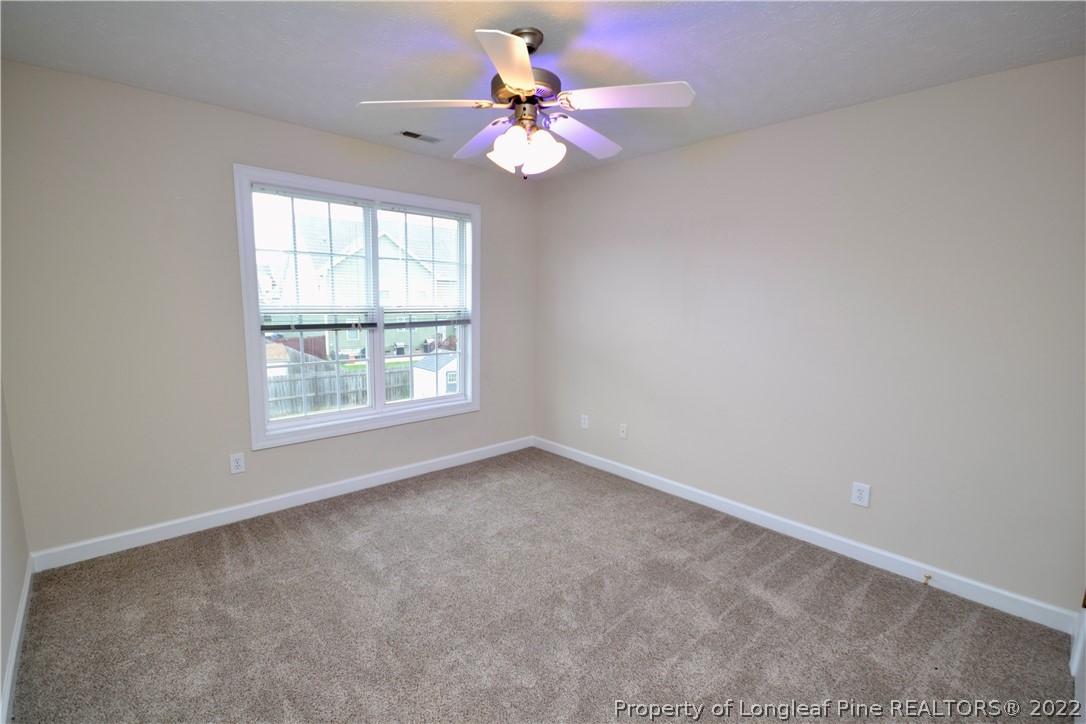 3608 Talus Road Fayetteville, NC 28306 - Photo 32 of 46 an empty room with windows and chandelier fan