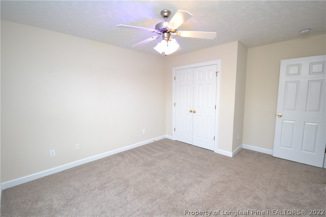 3608 Talus Road Fayetteville, NC 28306 - Photo 33 of 46 an empty room with a chandelier fan and windows