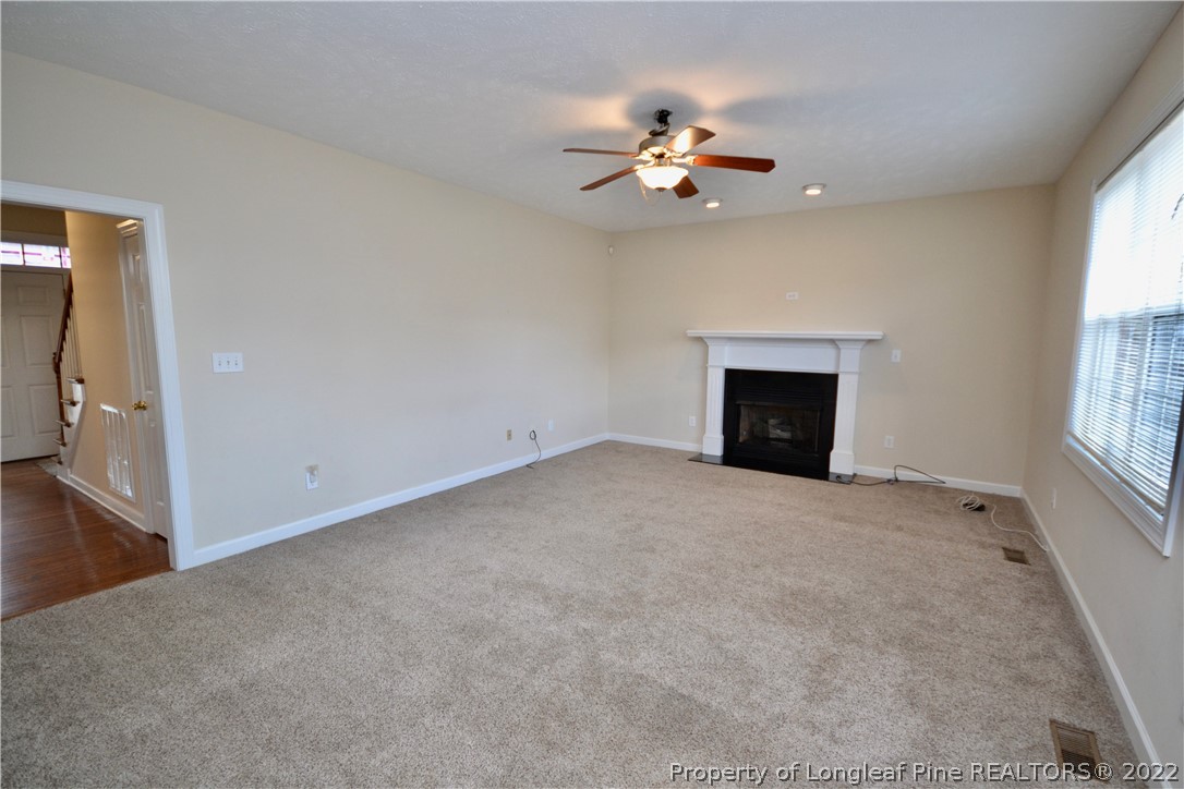3608 Talus Road Fayetteville, NC 28306 - Photo 10 of 46 an empty room with chandelier fan and windows