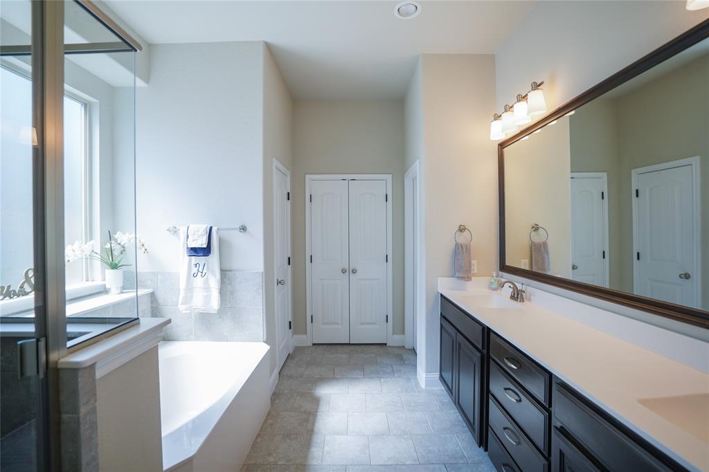 3009 Treasure View Drive Decatur, TX 76234 - Photo 14 of 26 Bathroom featuring a closet, double vanity, a garden tub, and light tile patterned flooring