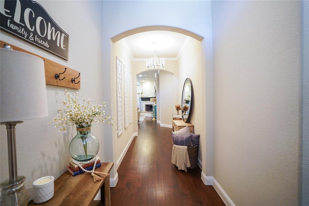 3009 Treasure View Drive Decatur, TX 76234 - Photo 6 of 26 Hallway featuring arched walkways, dark wood-style floors, crown molding