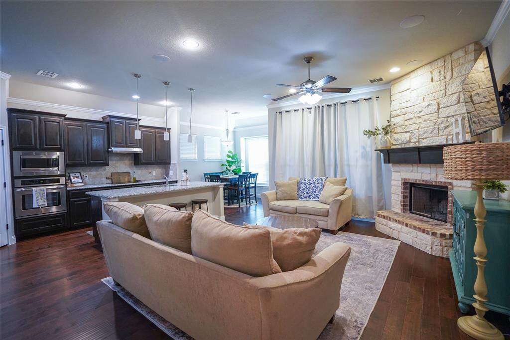 3009 Treasure View Drive Decatur, TX 76234 - Photo 10 of 26 Living room with a ceiling fan, dark wood finished floors, crown molding, and a fireplace