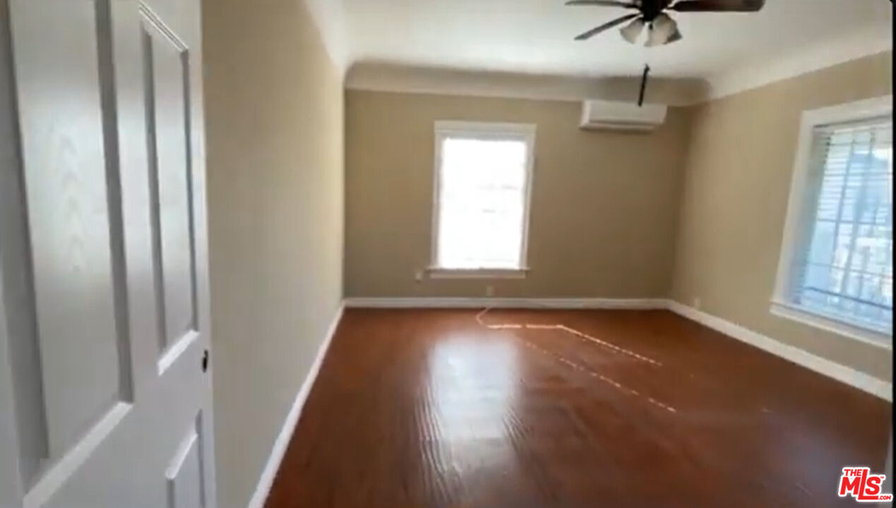 1284 West 38th Street Los Angeles, CA 90037 - Photo 14 of 14 an empty room with wooden floor fan and windows