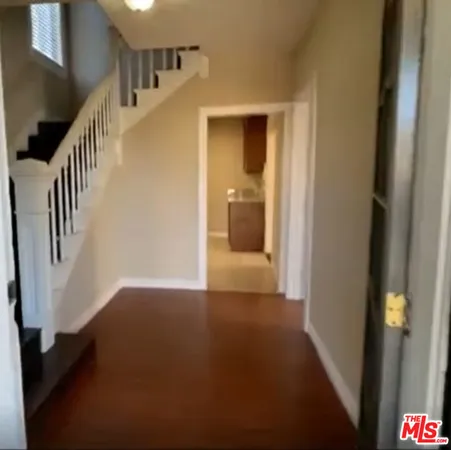 a view of a hallway with wooden floor and entryway