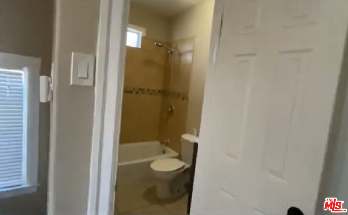 1284 West 38th Street Los Angeles, CA 90037 - Photo 3 of 14 a bathroom with a granite countertop sink toilet and shower