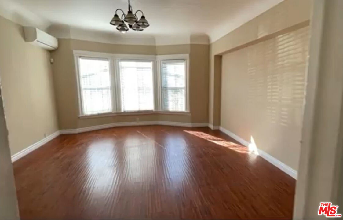 1284 West 38th Street Los Angeles, CA 90037 - Photo 5 of 14 an empty room with wooden floor and windows