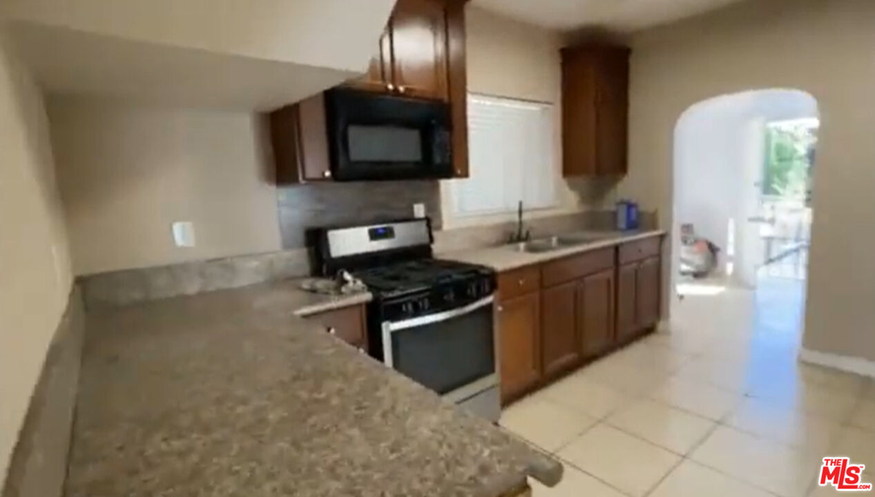 1284 West 38th Street Los Angeles, CA 90037 - Photo 8 of 14 a kitchen with stainless steel appliances a sink a stove and a microwave